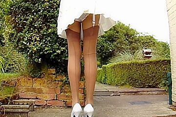 Tan Stockings With Pleated Skirt On A Windy Day